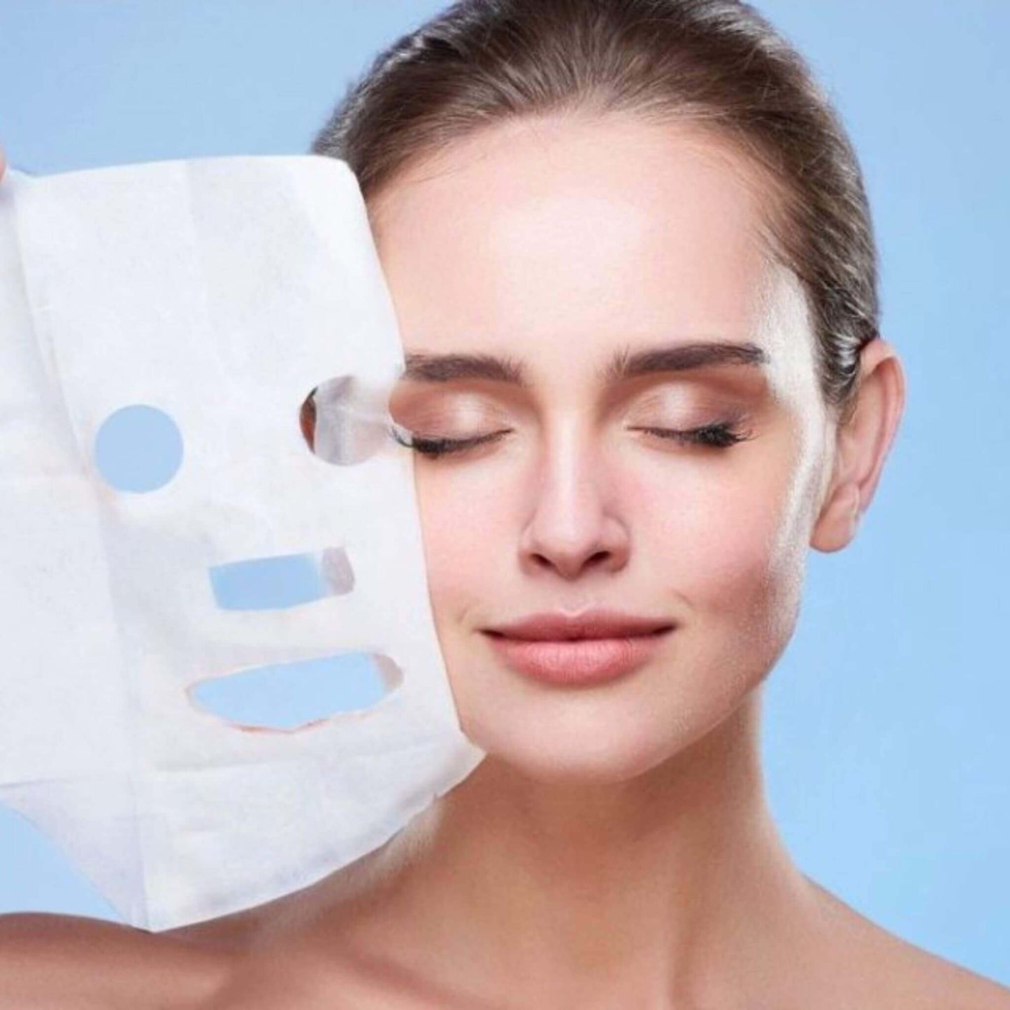 Woman applying a white sheet mask on her face with a blue background