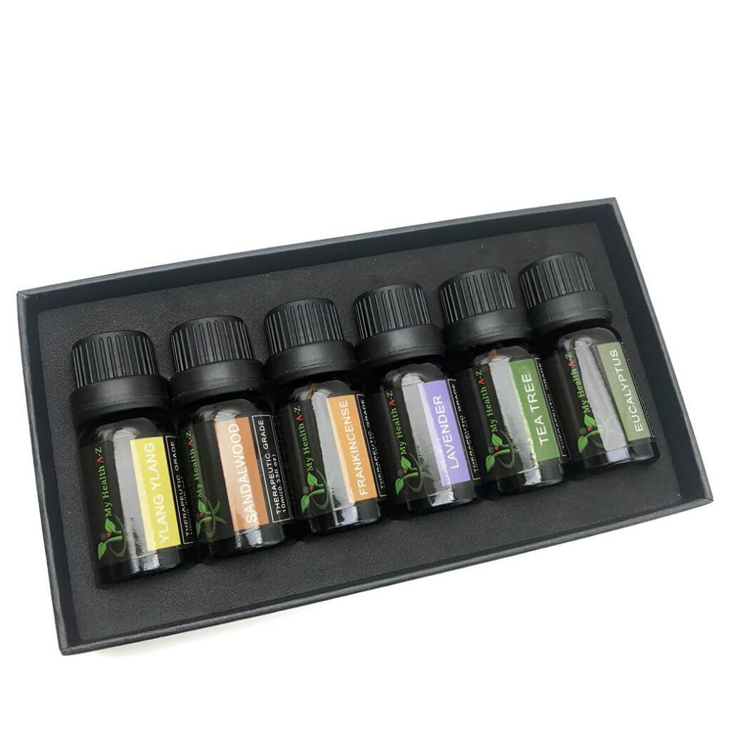 Set of essential oil bottles in a black box on a white background