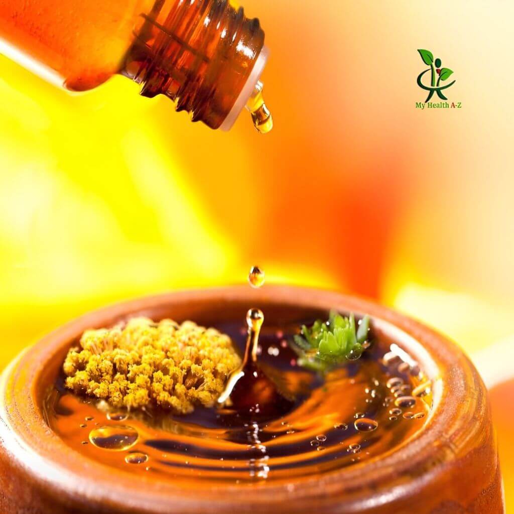 Bottle pouring rosemary essential oil into a container with a blurred background and 'My Health AZ' logo.