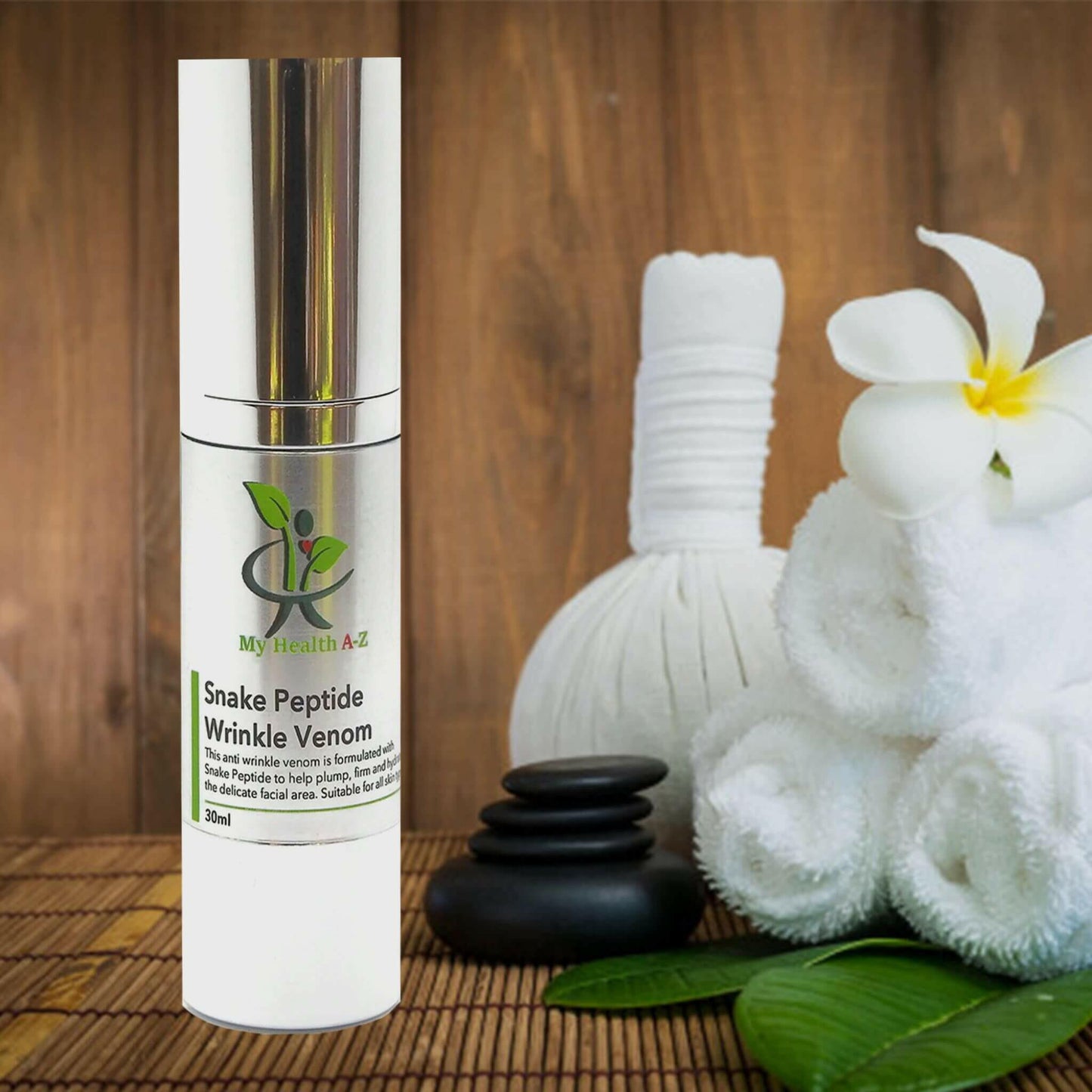 Snake Peptide Wrinkle Venom airless pump bottle next to some black stones and towels on a leaf