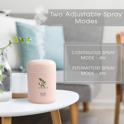 Pink humidifier on a table with text about adjustable spray modes in a living room setting.