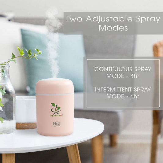 Pink humidifier on a table with text about adjustable spray modes in a living room setting.