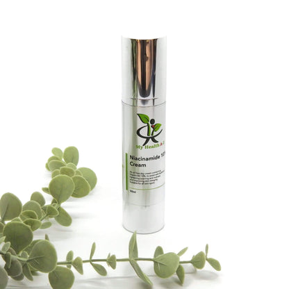 Skincare cream bottle with green leaves on a white background