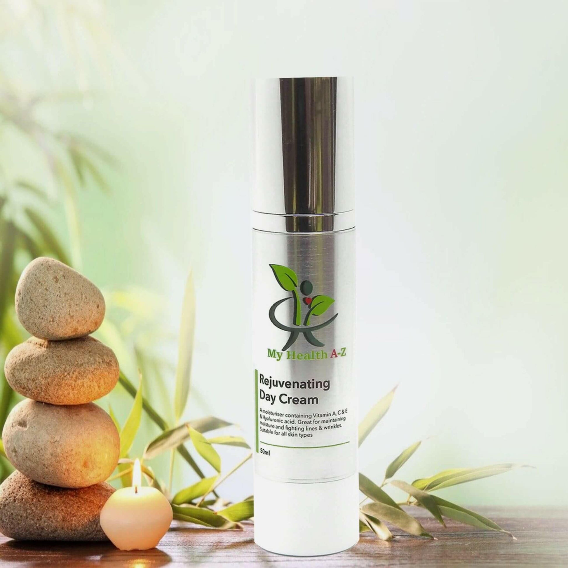 soft green leafs in the background yellow stacked rocks and a bottle of  rejuvenating day cream